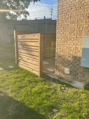 Jonesboro apartment for rent - a wooden fence in front of a brick building
