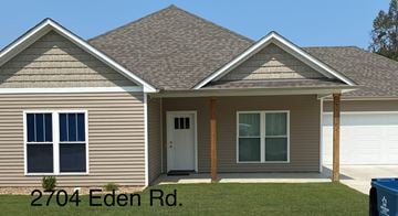 Benton house for rent - the front of a house with the front porch and a lawn