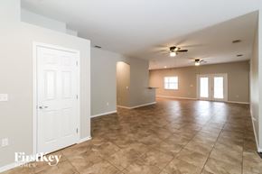 Zephyrhills house for rent - A spacious room with tile flooring and a ceiling fan.
