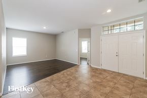 Zephyrhills house for rent - A spacious room with a tiled floor and white walls.