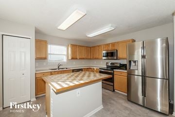 Avon house for rent - A kitchen with wooden cabinets and a stainless steel refrigerator.