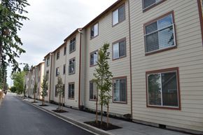Portland apartment for rent - a row of houses with trees in front of them on a street