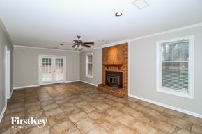 Memphis house for rent - a living room with a brick fireplace and a ceiling fan