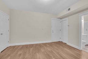 Washington apartment for rent - a bedroom with white walls and wood flooring and a door to a bathroom
