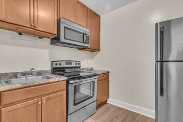 Washington apartment for rent - a kitchen with stainless steel appliances and wooden cabinets