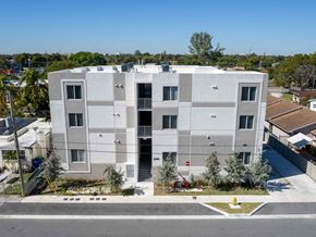 Miami apartment for rent - an aerial view of a white building with balconies
