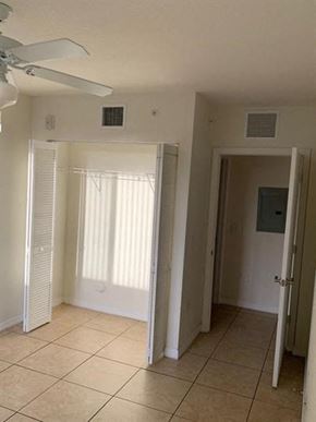 Miami apartment for rent - an empty room with a ceiling fan and a door