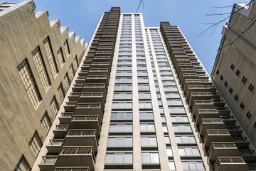 New York apartment for rent - a tall building with many balconies and a blue sky