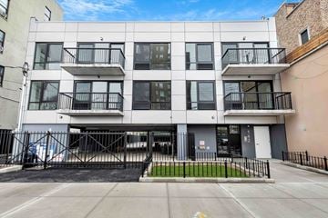 Brooklyn apartment for rent - A modern building with a black gate in front.