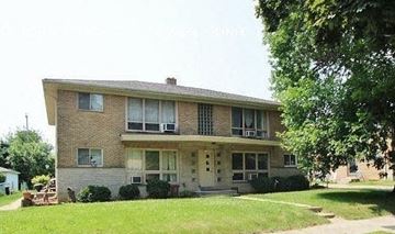 Milwaukee apartment for rent - A two-story house with a front porch and a tree in the front yard.