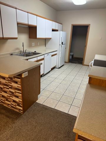 Fargo apartment for rent - A kitchen with white cabinets and a white refrigerator.
