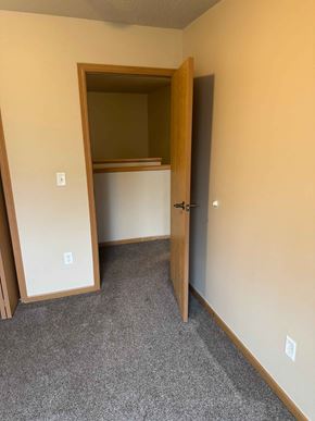 Fargo apartment for rent - A room with a carpeted floor and a doorway leading to another room.