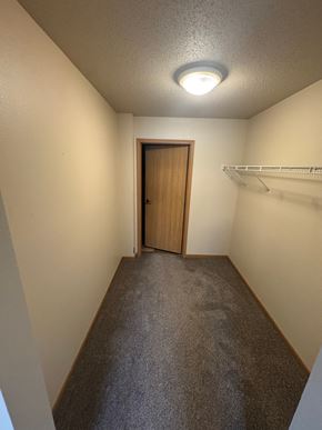 Fargo apartment for rent - A hallway with a door and a shelf.
