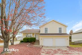 Kansas City house for rent - a yellow house with a tree in front of it