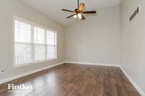 Kansas City house for rent - an empty living room with wood floors and a ceiling fan