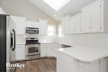 Kansas City house for rent - a white kitchen with white cabinets and stainless steel appliances