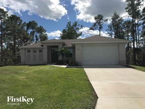 Lehigh Acres house for rent - a house with a lawn and a driveway
