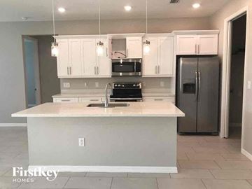 Lehigh Acres house for rent - a kitchen with white cabinets and a counter top