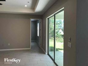 Lehigh Acres house for rent - an empty hallway with glass doors and a tiled floor