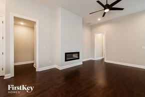 Cordova house for rent - A spacious room with a fireplace and a ceiling fan.