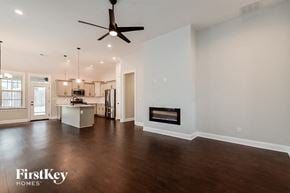 Cordova house for rent - A spacious living room with a fireplace and a kitchen in the background.