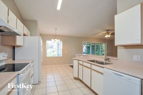 Palm Coast house for rent - a kitchen with white cabinets and a sink and a refrigerator