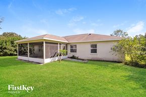 Palm Coast house for rent - a small white house with a grass yard and a covered porch