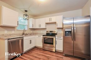 Palm Coast house for rent - a kitchen with stainless steel appliances and white cabinets