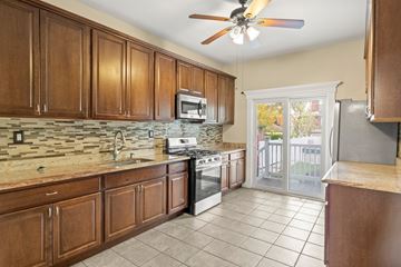 Jersey City apartment for rent - A kitchen with wooden cabinets and a tile backsplash.