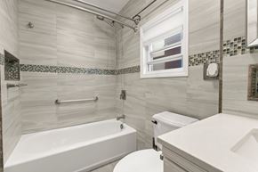 Jersey City apartment for rent - A white bathroom with a tub, toilet and sink.