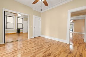 Jersey City apartment for rent - A room with wooden floors and a ceiling fan.