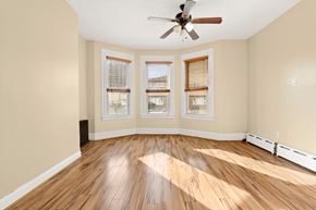 Jersey City apartment for rent - A room with a ceiling fan and wooden flooring.