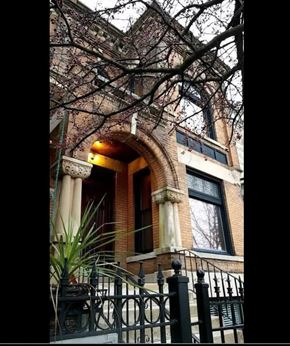 Chicago apartment for rent - A brick building with a black iron fence in front.