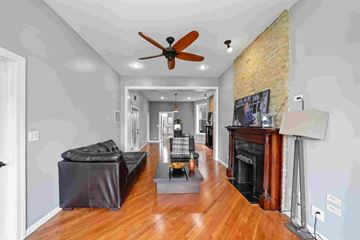 Chicago apartment for rent - A living room with a black couch and a fireplace.