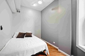 Chicago apartment for rent - A bedroom with a bed and a wall-mounted air conditioner.