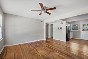 Roswell apartment for rent - A room with a ceiling fan and wooden floors.