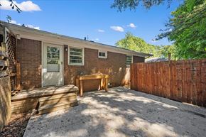 Roswell apartment for rent - A backyard with a wooden fence and a brick house.