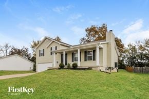 Troy house for rent - a beige house with a lawn in front of it