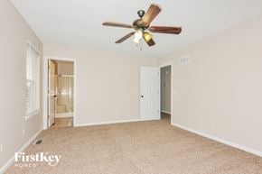 Troy house for rent - a bedroom with a ceiling fan and a door to a bathroom