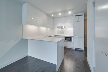 Edmonton apartment for rent - A modern kitchen with white cabinets and a stainless steel oven.