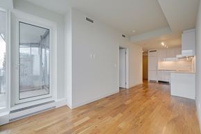 Edmonton apartment for rent - A spacious room with wooden floors and white walls.