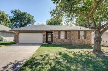 Springfield house for rent - the front of a brick house with a garage and a tree