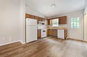 Jacksonville house for rent - an empty kitchen with white appliances and wooden floors