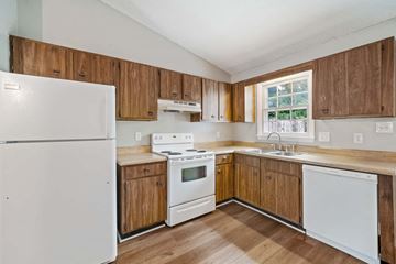 Jacksonville house for rent - a kitchen with white appliances and wooden cabinets