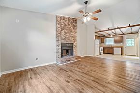 Jacksonville house for rent - A room with a fireplace and a ceiling fan.