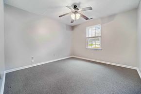 Jacksonville house for rent - A room with a ceiling fan and a window with blinds.