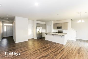 Huntersville house for rent - A spacious, well-lit kitchen and living room with wooden floors and white walls.