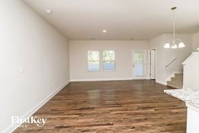 Concord house for rent - A spacious room with wooden flooring and white walls.