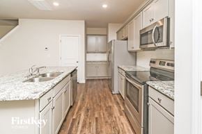 Concord house for rent - A kitchen with wooden floors and stainless steel appliances.
