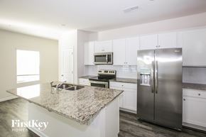 Concord house for rent - a white kitchen with stainless steel appliances and granite counter tops